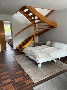 sypialnia z łóżkiem i drewnianymi schodami w obiekcie Storahuset Helsingborg w mieście Helsingborg