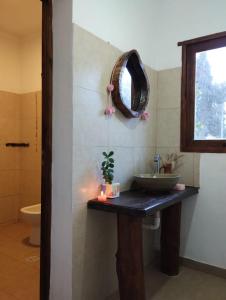 ein Bad mit einem Waschbecken und einem Wandspiegel in der Unterkunft Luna Jatun in Purmamarca