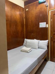 Cama en habitación con pared de madera en Querencia Inn, en Banaue