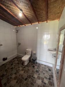 a bathroom with a toilet and a sink at D’Taman cabin Kintamani in Kubupenlokan