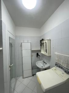 uma casa de banho branca com um lavatório e uma cama em La casa di Dafne em Messina
