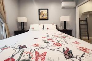 a bedroom with a bed with a floral bedspread at Detached Guesthouse in Monrovia/Los Angeles in Monrovia