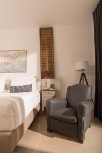 a bedroom with a bed and a chair at Hôtel 96 in Marseille
