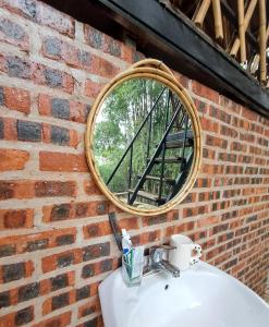 a mirror on a brick wall above a sink at Muong Bi Homestay - Uncle Lon - Luy Ai village in Hòa Bình +121 photos