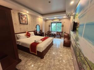 a hotel room with a bed and a living room at Khách Sạn Nam Sơn in Hai Phong