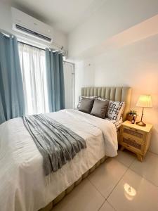 a bedroom with a large bed and a window at City Nest Makati with Rooftop pool and Free Netflix in Manila