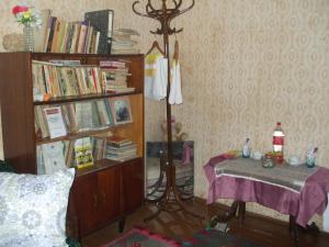 a room with a table and a book shelf with books at Daneto Rooms in Targovishte