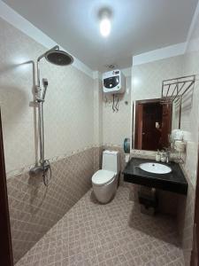 y baño con aseo, lavabo y ducha. en Khách Sạn Nam Sơn, en Hai Phong