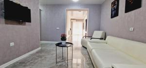 sala de estar con sofá blanco y mesa en nest1, Новое белье, есть бесплатная парковка en Kutaisi