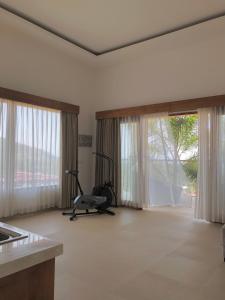 a living room with a treadmill in front of windows at Maya Villa in Candidasa