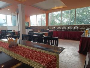 ein Restaurant mit Tischen und Stühlen in einem Zimmer in der Unterkunft Green Trees Munnar in Munnar