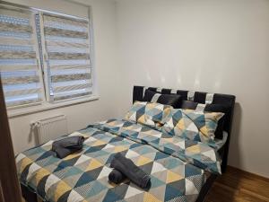 um quarto com uma cama com um cobertor e almofadas em REA em Pasuljište