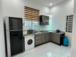 a kitchen with a washer and dryer in it at Aisy Guest House - MUSLlM Only in Kangar