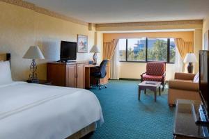 a hotel room with a bed and a chair and a television at Albuquerque Marriott Pyramid North in Albuquerque