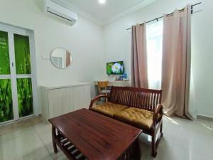 sala de estar con banco de madera y ventana en Villa Dracaena Melaka With Swimming Pool, Hill View and 20 minutes to Town en Melaka