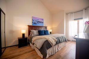 a bedroom with a large bed with blue pillows at Fairway Nine 4369 - Updated Condo in the Heart of Elkhorn Resort in Sun Valley