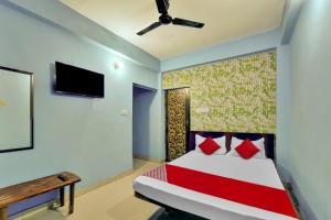 a bedroom with a bed and a tv on the wall at Super OYO Flagship Glad Guest House in Patna