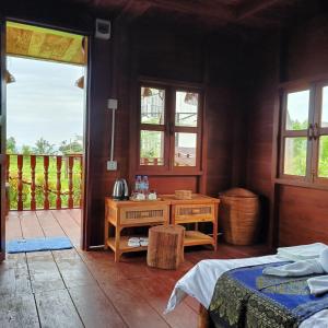 1 Schlafzimmer mit 2 Betten, einem Tisch und einer Tür in der Unterkunft ThmorDa Resort in Koh Rong Sanloem