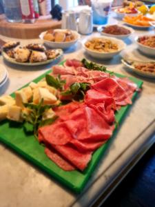 einen Tisch mit einem Haufen verschiedener Arten von Speisen in der Unterkunft Dimora Fiore in Lucca