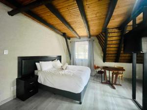 um quarto com uma cama e uma mesa num quarto em The Eden Boulders Hotel and Resort Midrand em Midrand