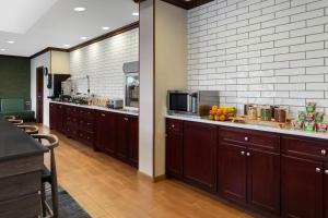 a kitchen with wooden cabinets and a counter with a microwave at Fairfield Inn Charlotte Mooresville Lake Norman in Mooresville