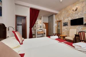 una camera d'albergo con un grande letto e un bagno di Heritage Hotel Tragos a Trogir