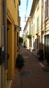 an empty alley way with buildings on either side at Safranier Townhouse in Antibes