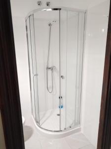 a shower with a glass enclosure in a bathroom at Pensión A&E in Manises