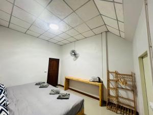 Zimmer mit 2 Betten und einem Tisch in der Unterkunft Lungwang Guest House in Ban Rak Thai