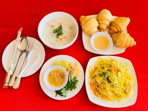 a table with plates of food on a red background at Lungwang Guest House in Ban Rak Thai