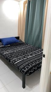 Cozy 2 Bedroom (Entire House) Pearson Residences في Hulugan: سرير صغير في غرفة ذات ستارة