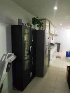 eine Küche mit einer schwarzen Tür und einem Kühlschrank in der Unterkunft Cozy 2 Bedroom (Entire House) Pearson Residences in Hulugan