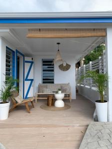 a patio with a couch and a bench on a porch at Gite Ti Bali in Deshaies