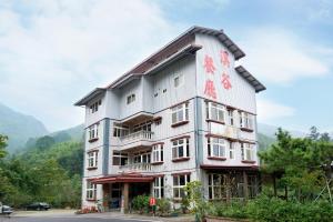 un edificio blanco alto con escritura china. en Nantou Xitou Riverside Homestay B&B en Lugu