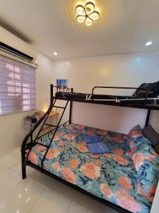- une chambre avec des lits superposés et un couvre-lit floral dans l'établissement Cozy 2 Bedroom (Entire House) Pearson Residences, à Hulugan