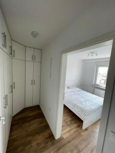 um quarto branco com uma cama e um espelho grande em Martin’s flat in the city centre em Ljubljana
