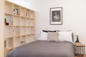 a bedroom with a bed and book shelves at Apartament Okrzei in Płock