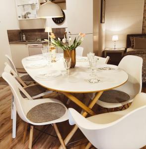 a white dining room table with white chairs and a white table and chairsktop at Apartment for family & friends in Eisingen