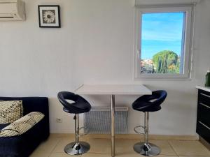 - un salon avec une table et deux chaises dans l'établissement T3 Cosy et spacieux - 4 à 6 couchages - climatisé, calme proche étang de Thau, à Marseillan