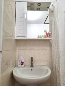 a bathroom with a sink and a mirror at ЕКО-квартира на Садововому. Мережа Alex Apartments. Цілодобове безконтактне заселення in Shcherbani