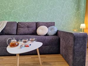 a living room with a purple couch and a table at ЕКО-квартира на Садововому. Мережа Alex Apartments. Цілодобове безконтактне заселення in Shcherbani