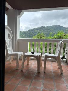 Duas cadeiras e uma mesa numa varanda com vista em H.R.K.Resort em Patong Beach