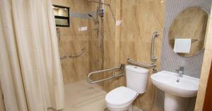 ein Bad mit einer Dusche, einem WC und einem Waschbecken in der Unterkunft Dancels Inn in Ormoc City