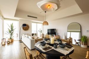 een woonkamer met een tafel en een bank bij Voyage 2 Bedroom In Mayan With Ocean Views in Abu Dhabi