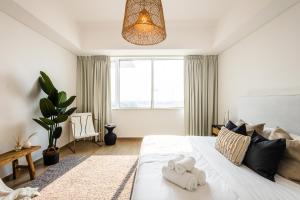 ein Schlafzimmer mit einem großen weißen Bett mit Handtüchern darauf in der Unterkunft Voyage 2 Bedroom In Mayan With Ocean Views in Abu Dhabi + 31 Fotos