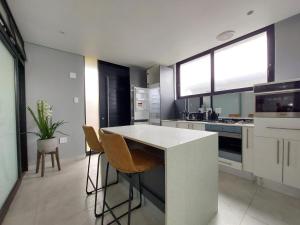 a kitchen with a counter and some chairs in it at Ntomb'lele Ocean View Luxury Holiday Villas in Tugela Mouth