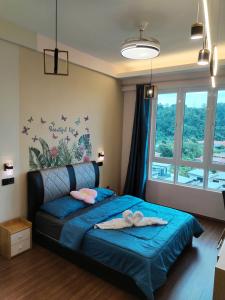 a bedroom with a bed with blue sheets and a window at Double Nine Homestay - Sri Indah Condominium in Sandakan