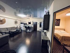 ツァグカゾールにあるTsaghkazdor luxury apartmentのリビングルーム(ソファ、ベッド付)、キッチンが備わります。