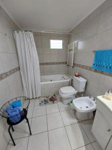 a bathroom with a toilet and a tub and a sink at Patagonia Relax in Comodoro Rivadavia
