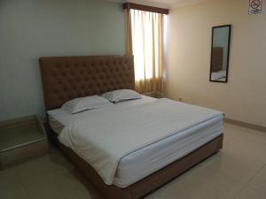 a large bed in a bedroom with a window at Zen Boutique Syariah Hotel in Jakarta